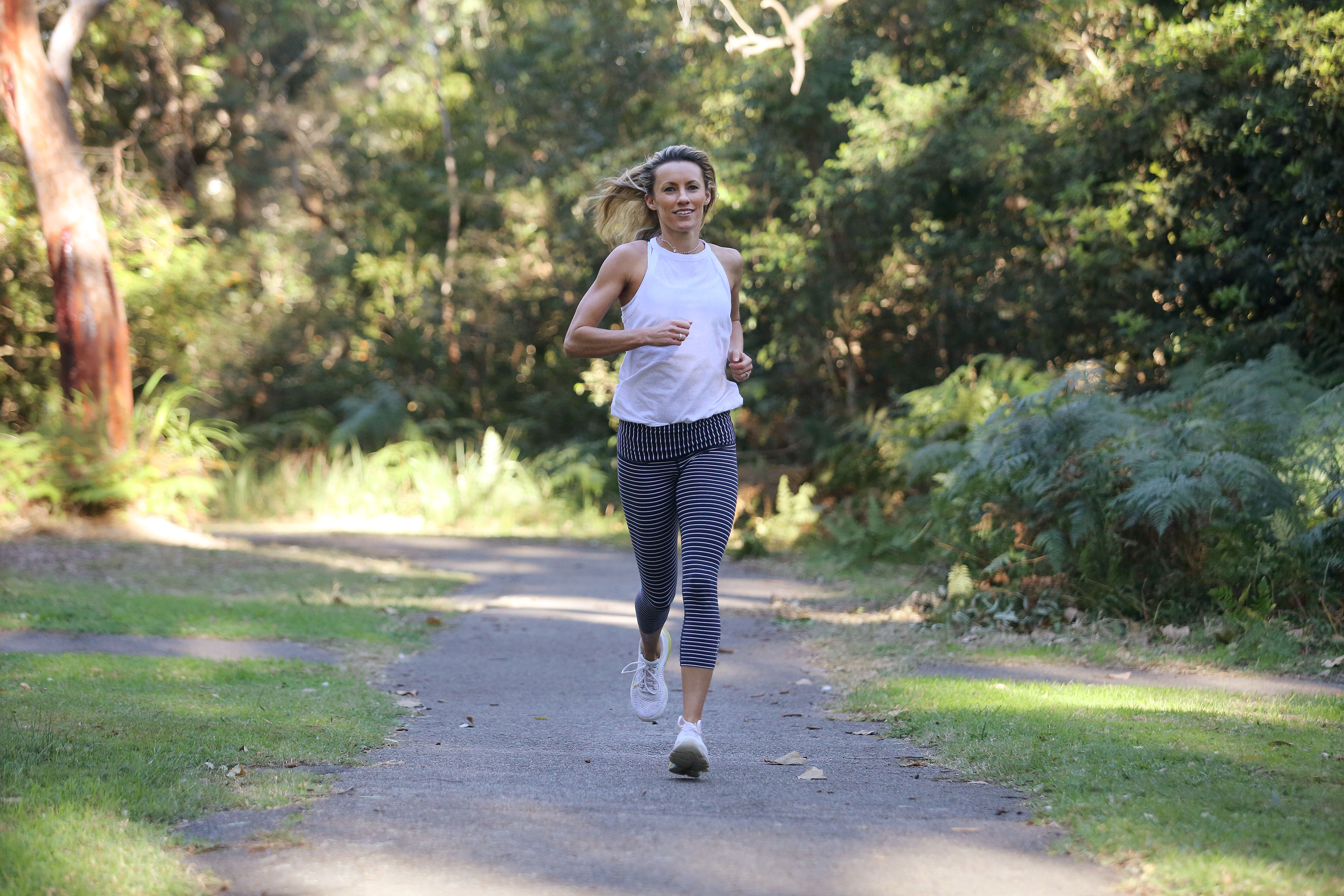 Woman running along bush track