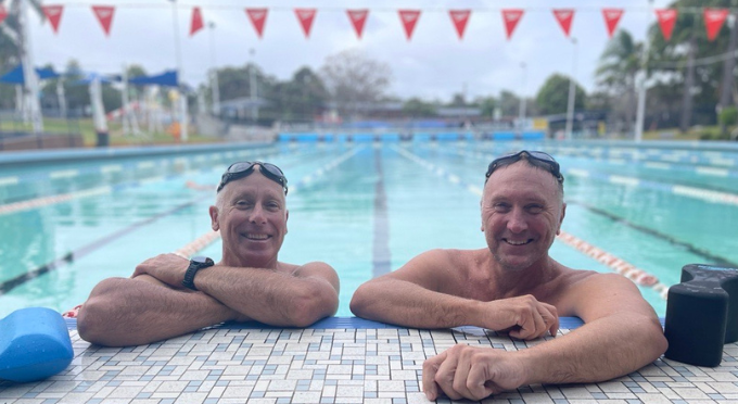 Two swimmers smiling in the pool